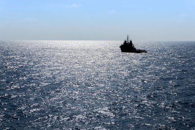 A silhouette of an anchor handling tug boat maneuvering at offshore terengganu oil field