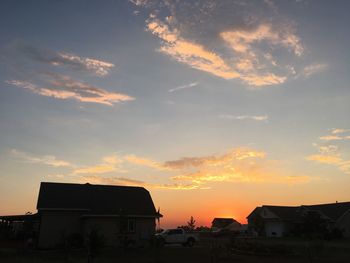 Houses against sky during sunset