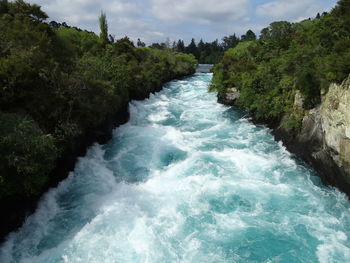 Scenic view of waterfall by sea against sky