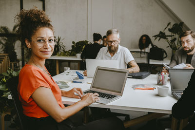 Portrait of businesswoman with laptop working in office