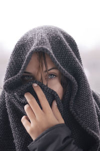 Close-up portrait of a young woman with hand in background