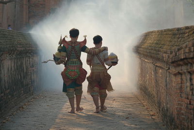 Rear view of people walking on road