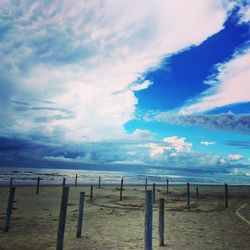 Scenic view of beach against cloudy sky