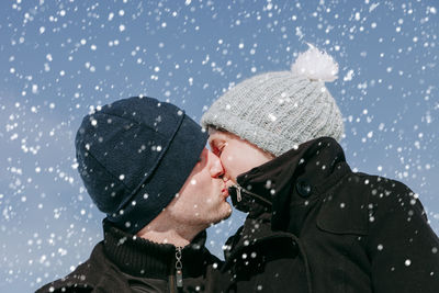 Man kissing woman during winter