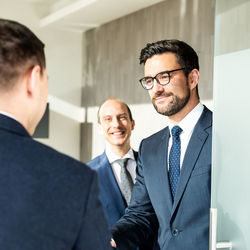 Businessmen shaking hands in office