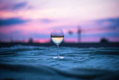 Close-up of drink against sunset sky