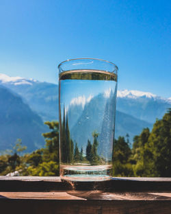 Close-up of glass of water against mountain