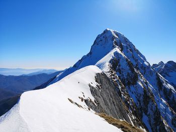 Scenic view of snowcapped mountains against clear blue sky