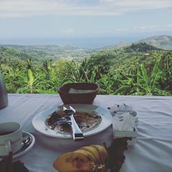Close-up of food on table by sea against sky