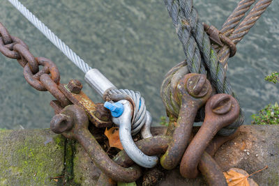 High angle view of chains and ropes tied up on mooring ring at harbor