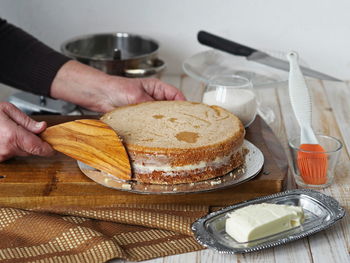 Midsection of man preparing cake on table