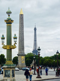 People in city against cloudy sky