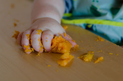 Close-up of hand holding bread on table