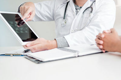Midsection of woman using laptop on table
