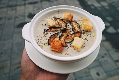 High angle view of hand holding noodles in bowl