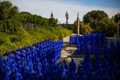 High angle view of people standing by plants against blue sky