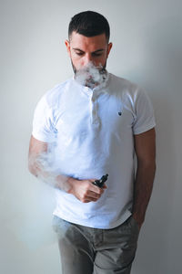 Man smoking against wall