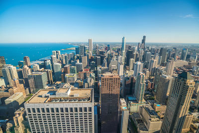 Aerial view of cityscape against clear blue sky