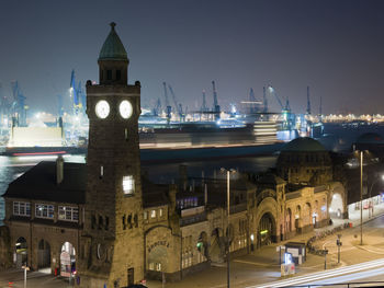 Illuminated buildings in city against sky at night