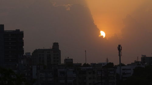 Silhouette cityscape against sky during sunset