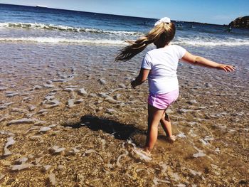 Rear view of girl standing on beach