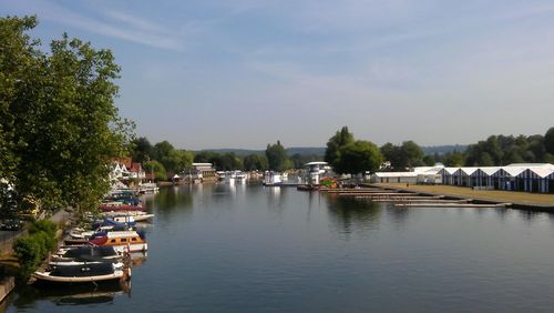 Boats moored in calm lake against the sky