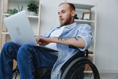 Portrait of young man using digital tablet while sitting in car