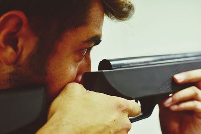 Close-up of man aiming with rifle