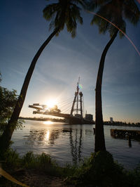 Silhouette of bridge over river against sky during sunset