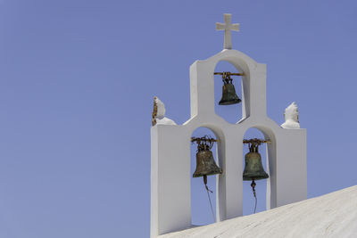 Santorini, greece, may 3, 2024. three bells of an orthodox church with a blue sky