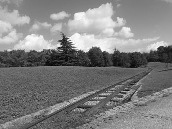 Railroad tracks by trees against sky