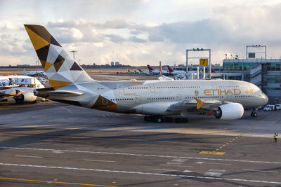 Airplane on airport runway against sky