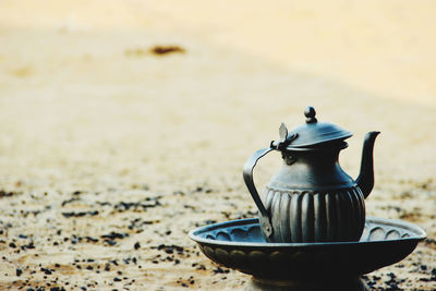 Close-up of tea cup on sand
