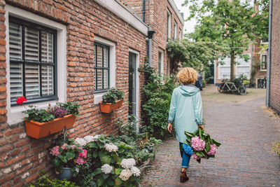 Rear view of woman standing against building