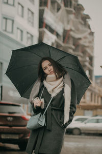 Woman standing on wet street in rain