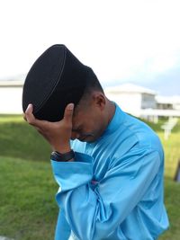 Man in traditional clothing standing against sky