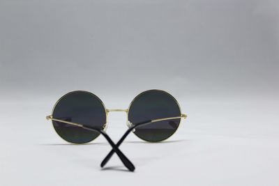 Close-up of sunglasses against sky over white background