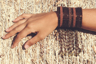 Cropped hand of woman on hay bale