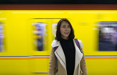 Portrait of woman standing on train at railroad station