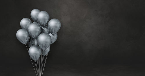 Close-up of balloons on table against black background