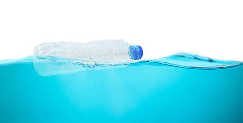 Close-up of bubbles over water against white background