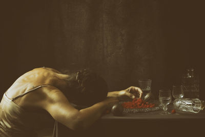 Woman offering a passion fruit between crystal crockery vii