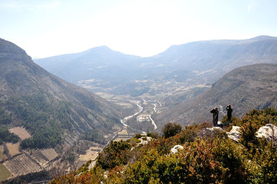 Rear view of people on mountain against clear sky