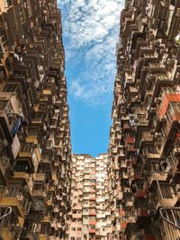 Low angle view of buildings against cloudy sky