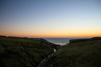 Scenic view of sea against clear sky during sunset