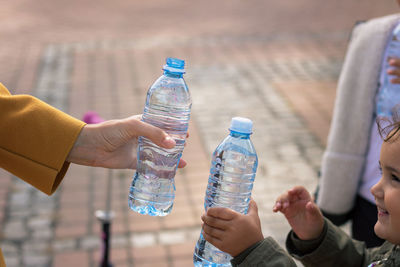 Mother and daughter holding water bottles in city