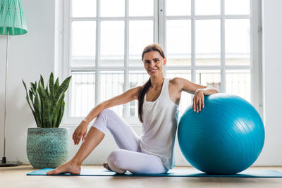 Portrait of young woman exercising at home