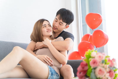 Young couple sitting on balloons