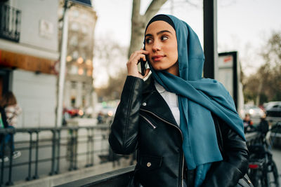 Young woman using mobile phone in city