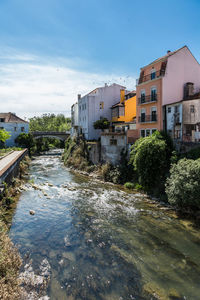 River by houses against sky